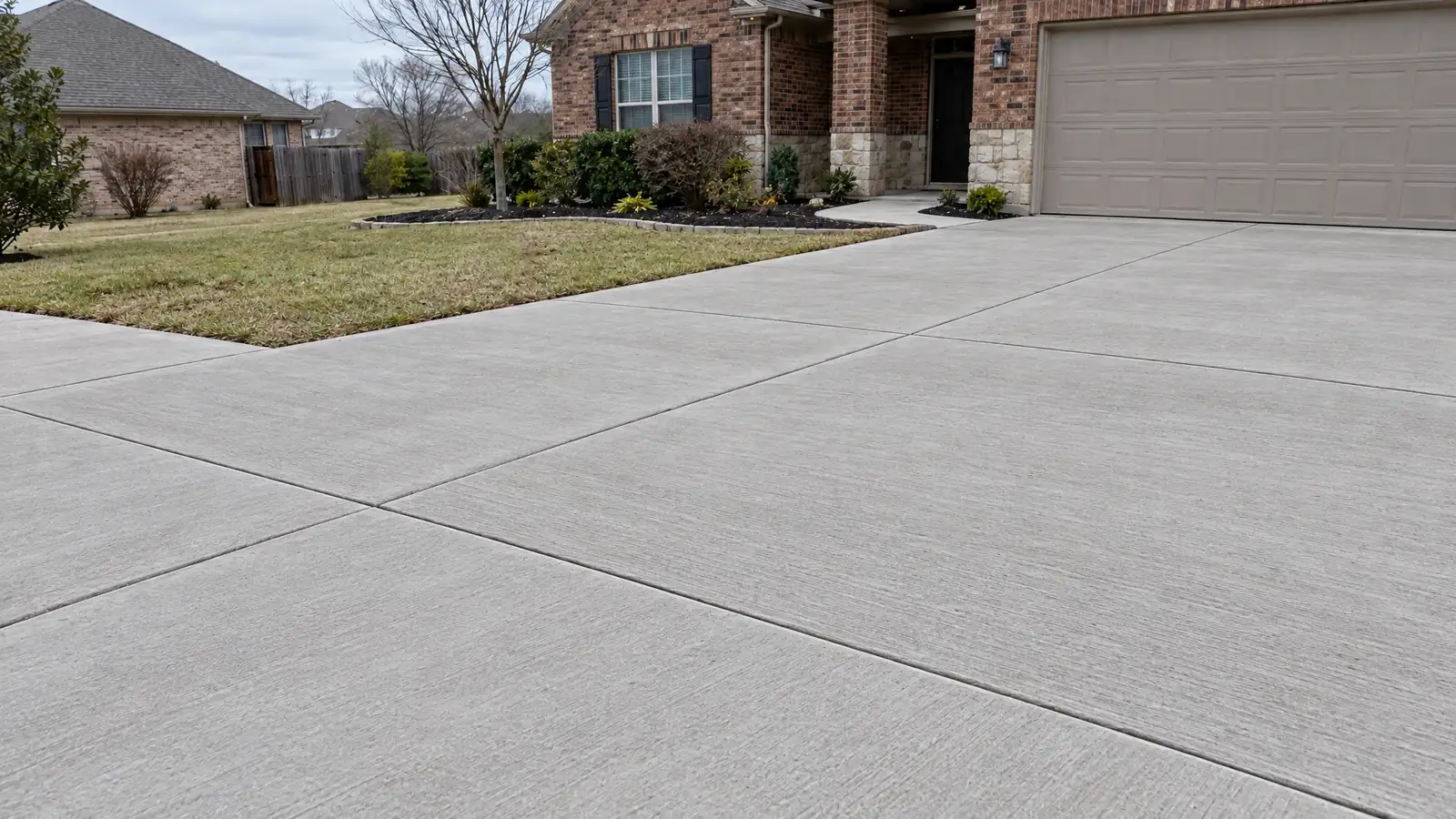 After: the same driveway patched with fresh smooth concrete and neat saw-cut edges